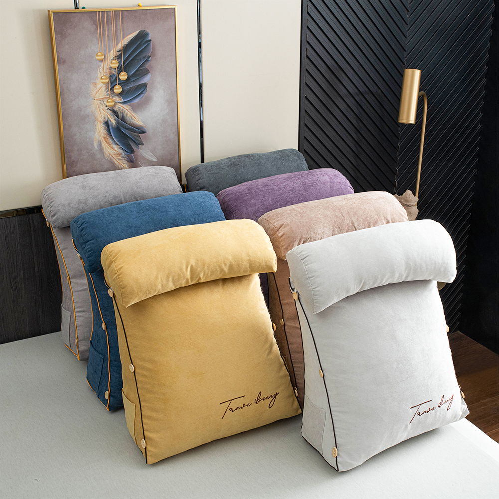 Colorful pillows on a light surface with a decorative wall in the background