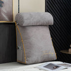 Gray wedge-shaped pillow with yellow accents on a surface, with a magazine open in front.