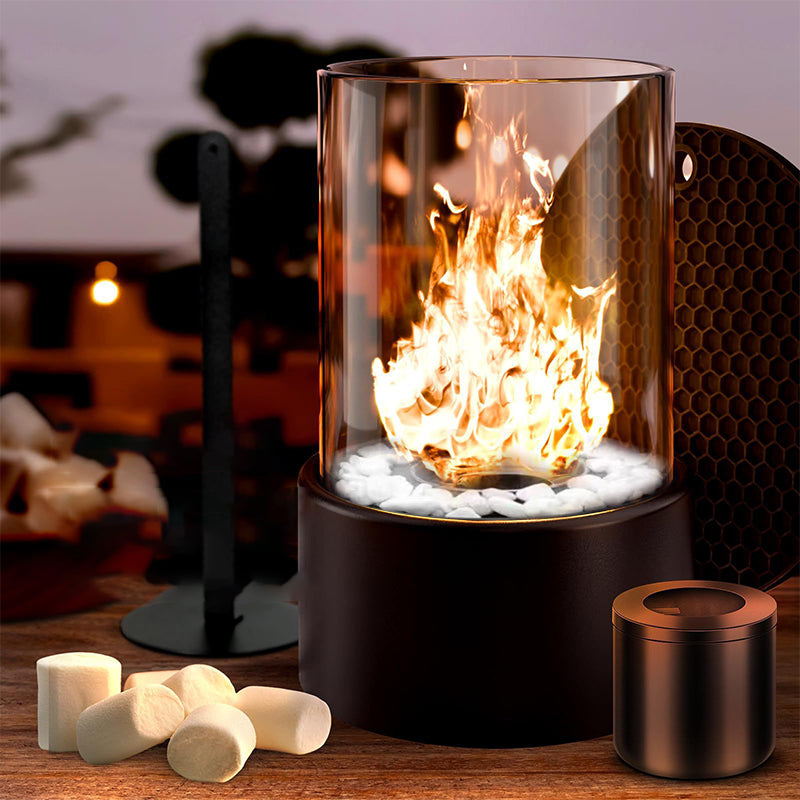 Glass container with flames on a wooden surface with marshmallows and a small black container.