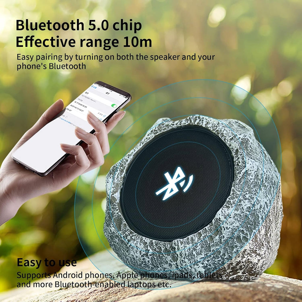Bluetooth speaker with stone-like texture and person holding phone with Bluetooth icon, outdoors.
