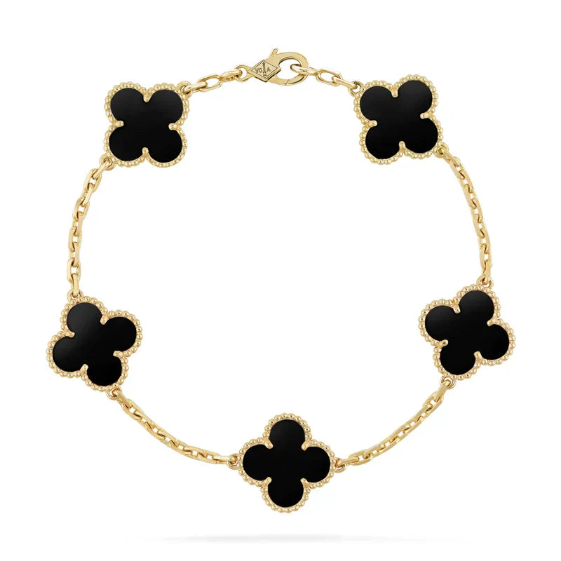 Gold bracelet with black clover-shaped charms on a white background