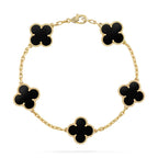Gold bracelet with black clover-shaped charms on a white background