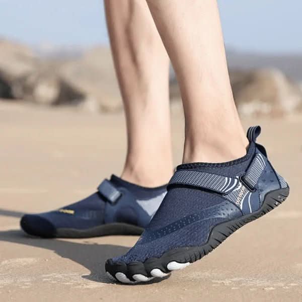 Navy blue water shoes worn on a sandy beach