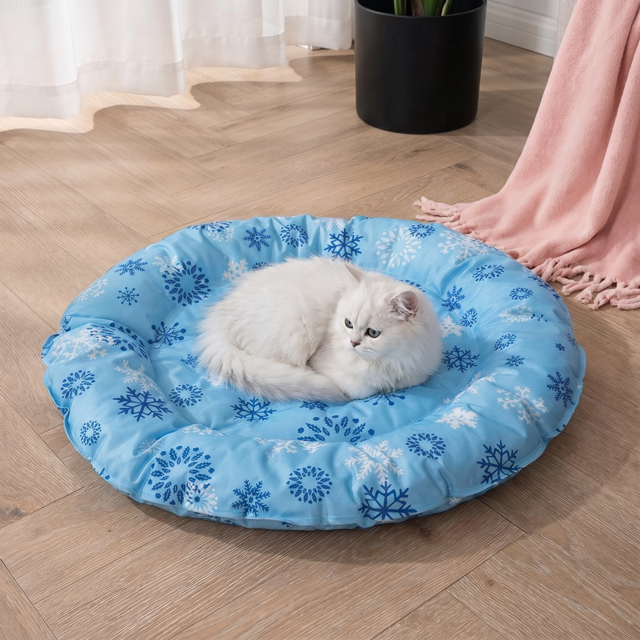 White cat lying on a blue pet bed with snowflake pattern on a wooden floor.