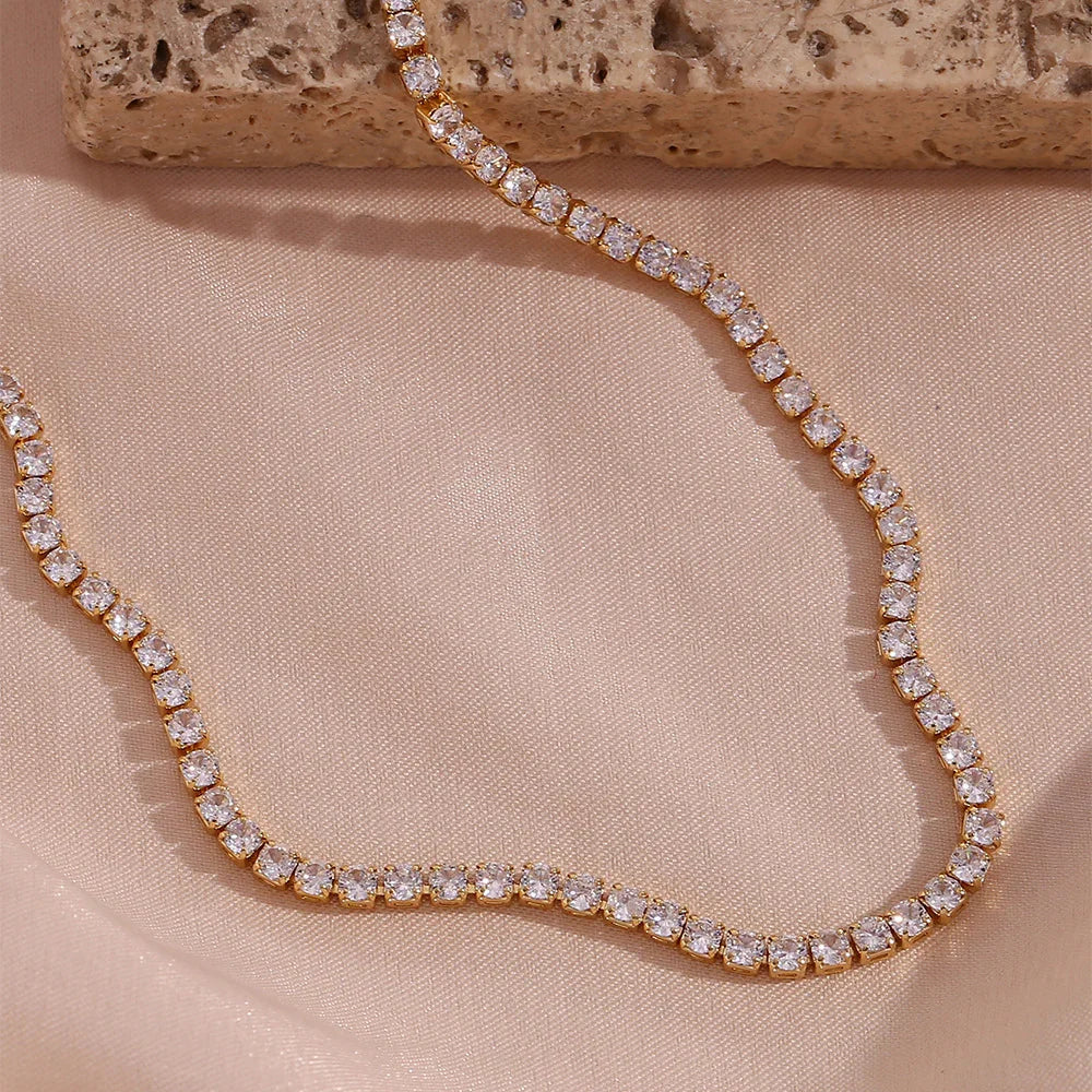 Rose gold necklace with clear stones on a beige fabric background