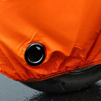 Close-up of an orange inflatable boat with a black valve on a dark surface