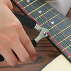 Person using a guitar string winder on a guitar neck