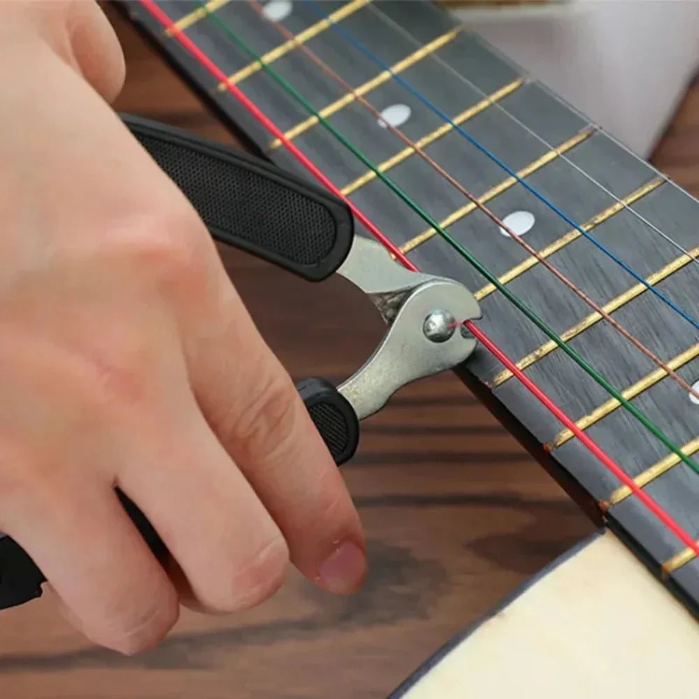 Person using a guitar string winder on a guitar neck