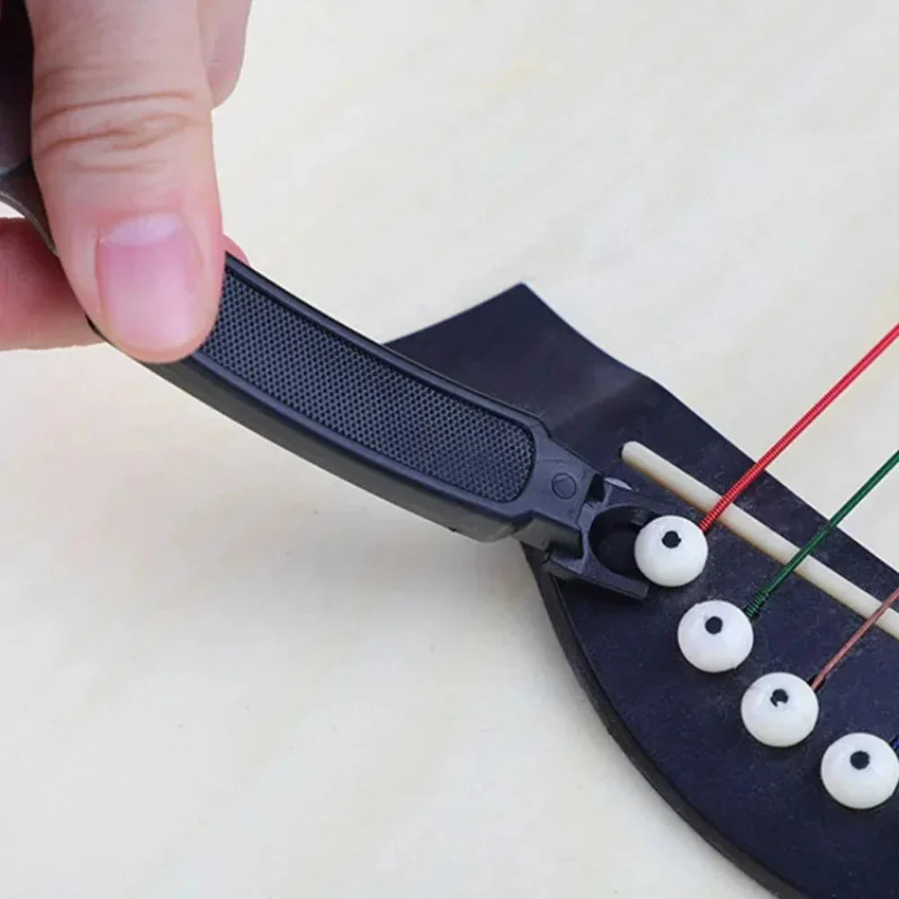 Close-up of a hand holding a small black device with strings and white beads on a light background