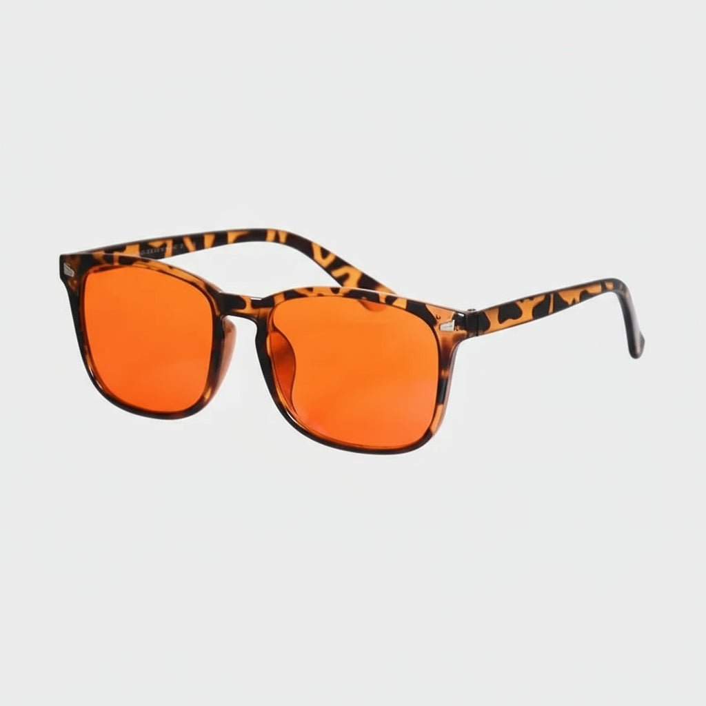 Sunglasses with orange lenses and tortoiseshell frame on a light gray background