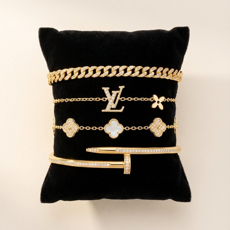 Gold jewelry on a black cushion with a visible brand logo