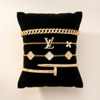 Gold jewelry on a black cushion with a visible brand logo