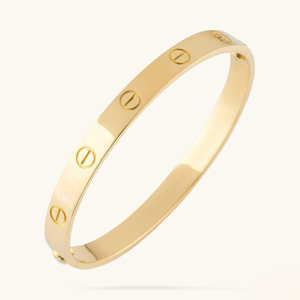 Gold bracelet with engraved design on a white background