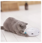 Gray cat interacting with a white electronic device on a tiled floor.