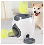 White and gray pet toy dispenser with a dog and tennis ball in the background