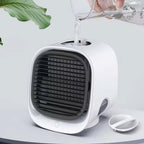 White and black air cooler on a light gray surface with a plant leaf in the corner.