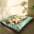 Dog lying on a green pet bed with 'Pet Heaven' branding in a room with curtains and a plant.
