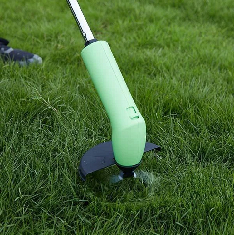 Green grass trimmer being used on a grassy area