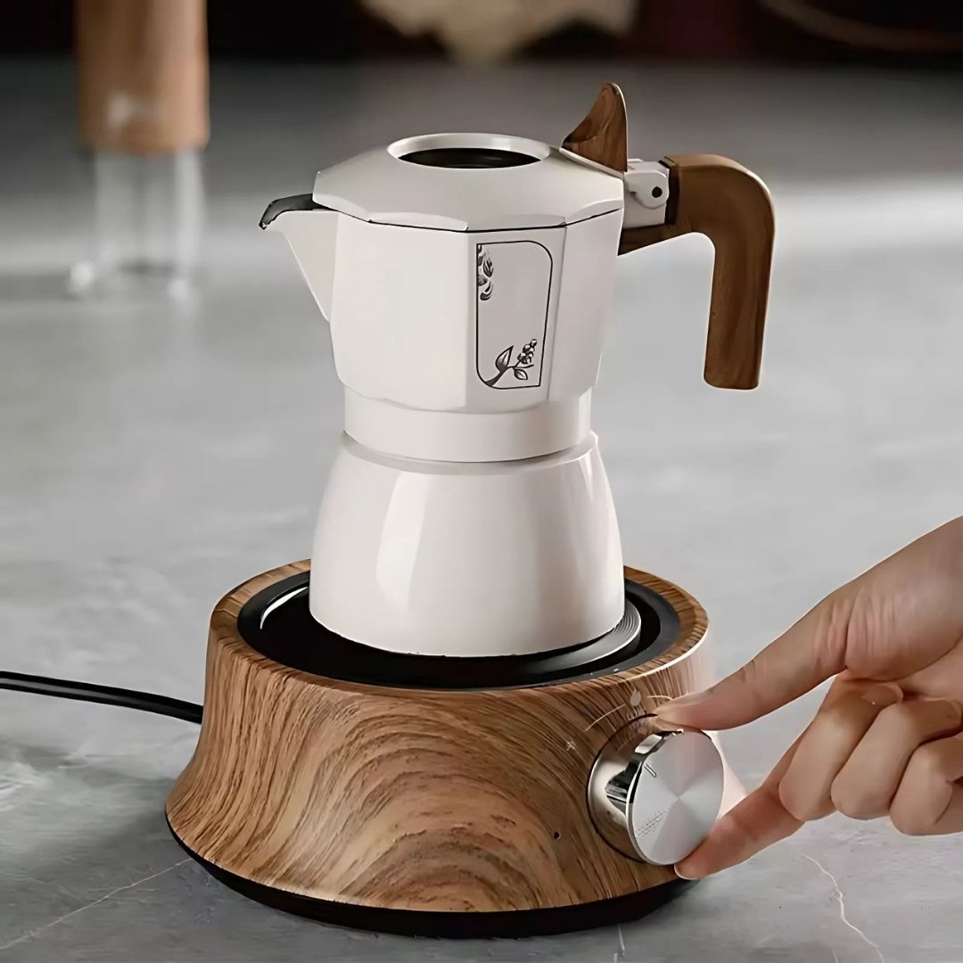 White coffee maker with wooden accents on a wooden base, being turned on by a hand.