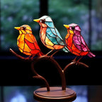 Stained glass birds on a stand with a blurred nature background