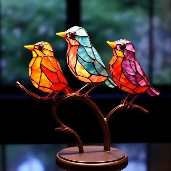 Stained glass birds on a stand with a blurred nature background