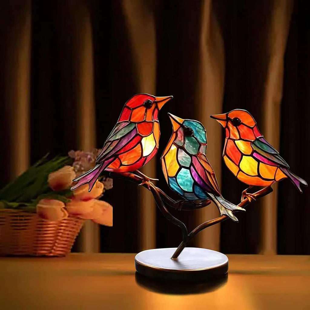 Colorful stained glass bird lamp on a wooden surface with a blurred background