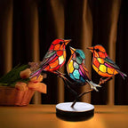 Colorful stained glass bird lamp on a wooden surface with a blurred background