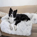 Dog lying on a fluffy white pet bed in a living room setting