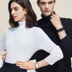 Two people wearing turtleneck sweaters against a plain background