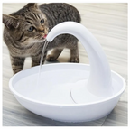 Cat drinking water from a white pet fountain on a light wooden floor.