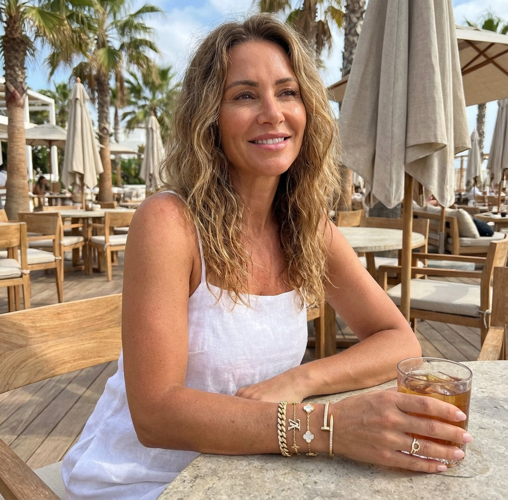Woman sitting at an outdoor cafe holding a drink