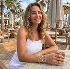 Woman sitting at an outdoor cafe holding a drink