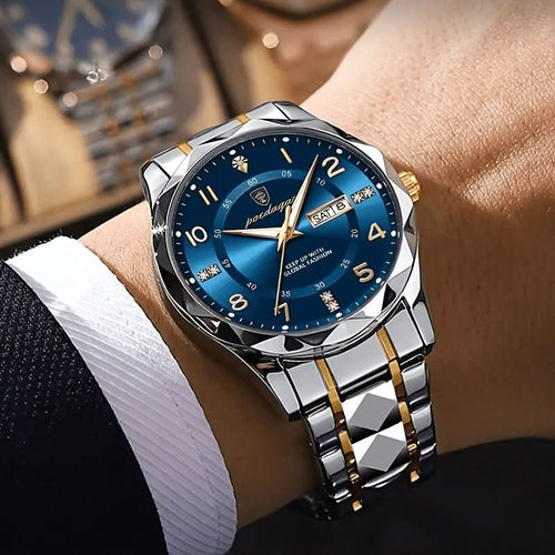 Luxury watch with blue dial and silver and gold bracelet on a wrist.