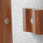 Wooden wall hooks with metal circular plates on a textured white background