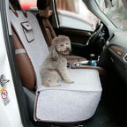 Dog sitting on a car seat cover in a vehicle