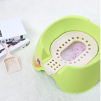 Green pet litter box with a scoop on a white surface