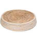 Round woven coaster with natural and white patterns on a white background
