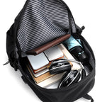 Black backpack with striped lining containing electronic devices and books on a white background