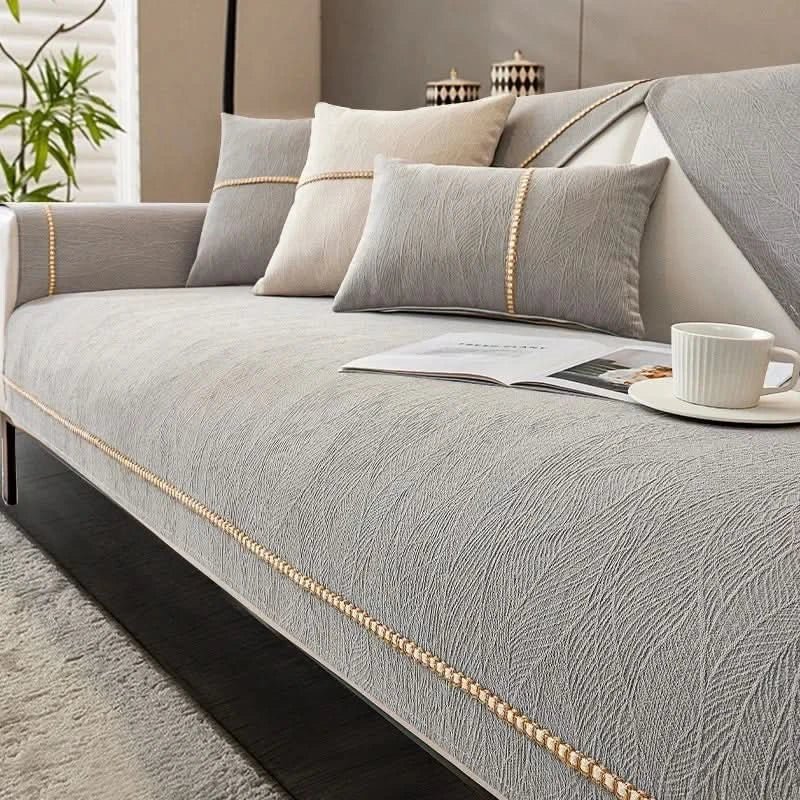 Gray sofa with decorative pillows and a cup on a saucer in a living room setting.