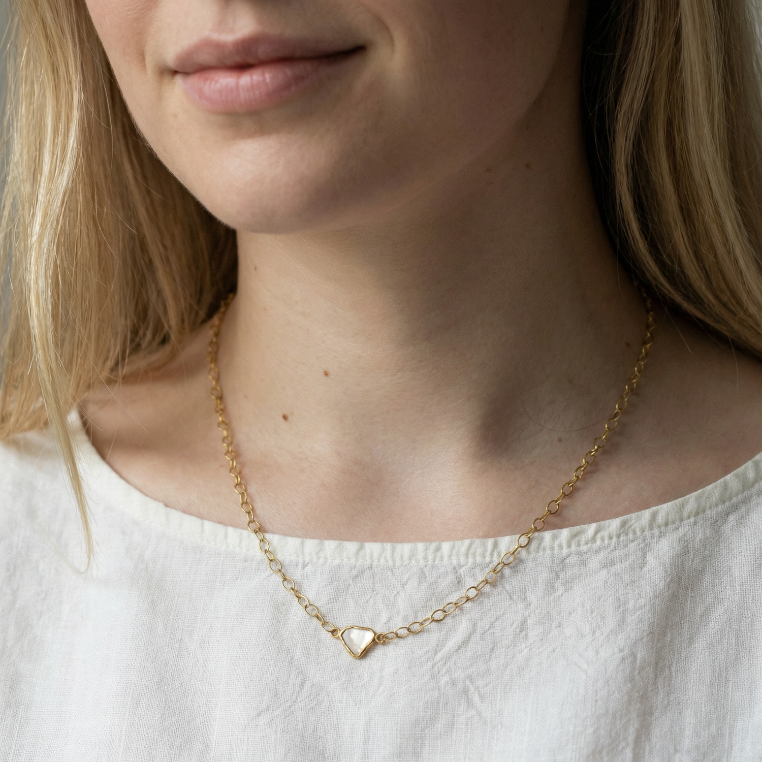 Close-up of a person wearing a 22ct gold necklace with a diamond slice pendant.Handcrafted by Ram Rijal