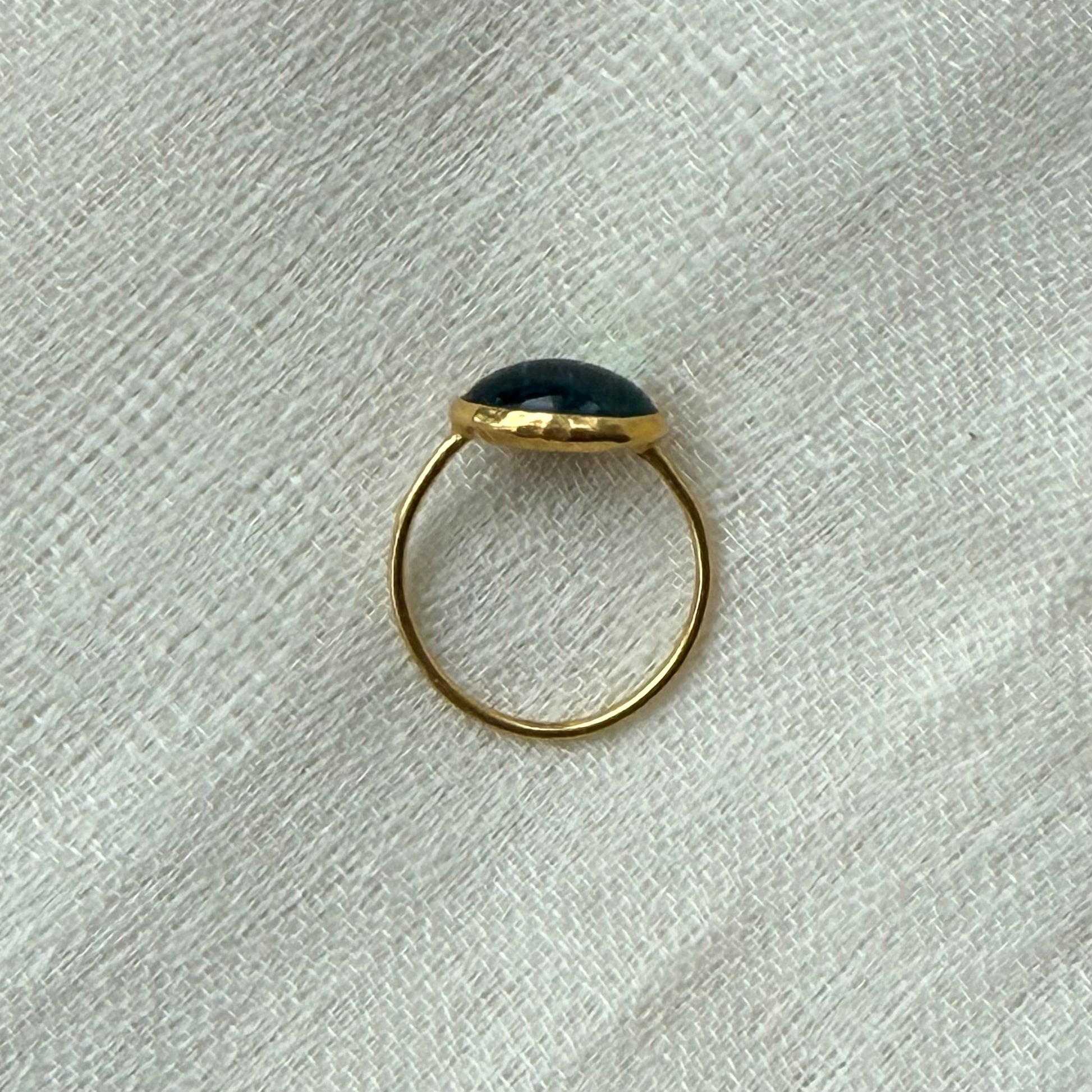 22ct Gold ring with a tourmaline stone on a textured white background