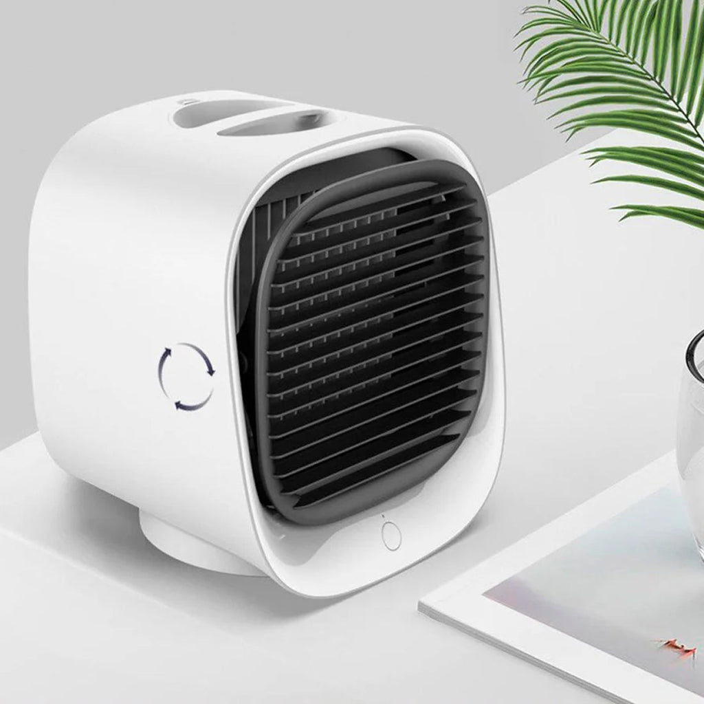 White portable air conditioner on a light gray surface with a plant in the background