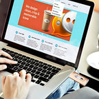 Person using a laptop with a design-themed website displayed on the screen.