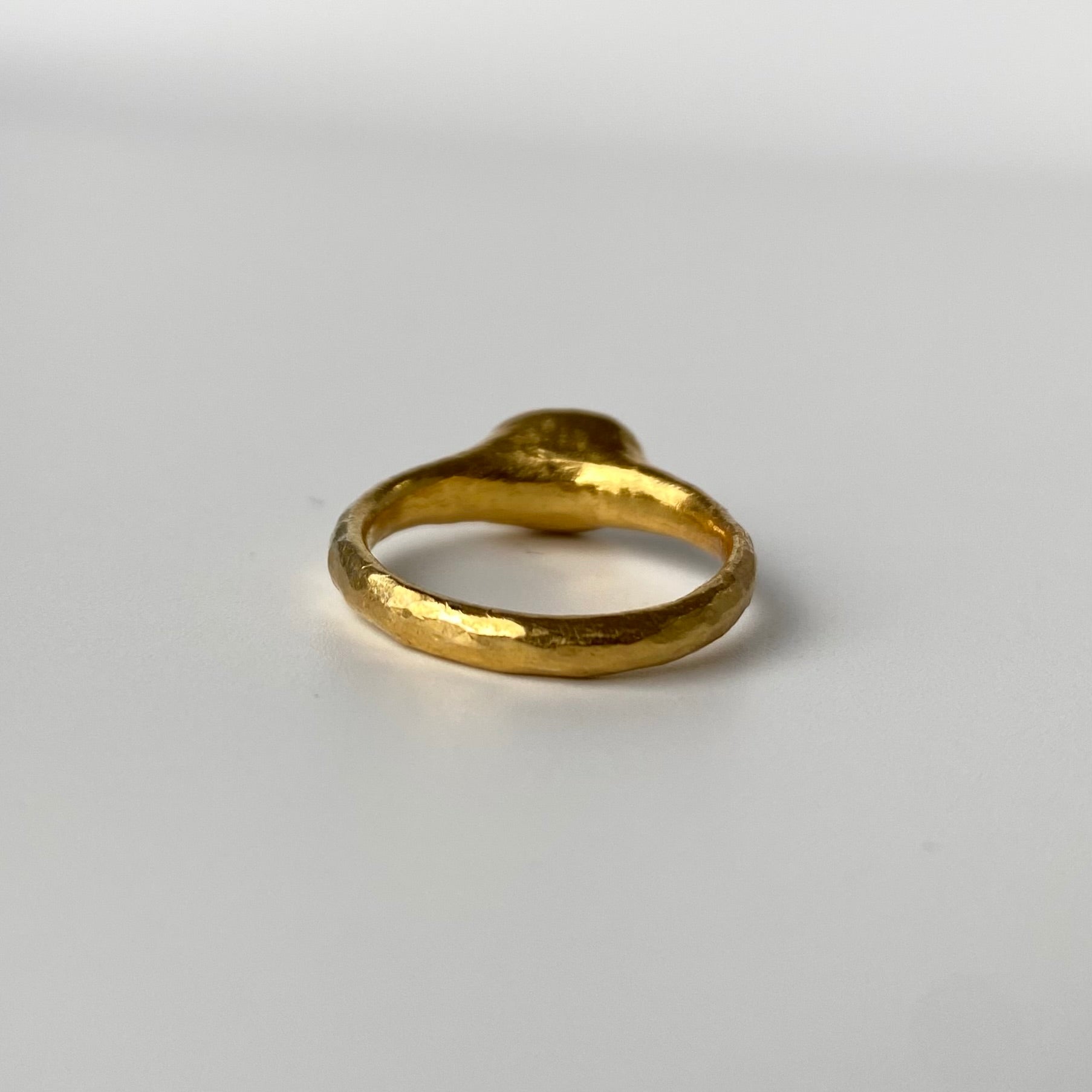 Handcrafted 22ct Gold ring on a light gray background