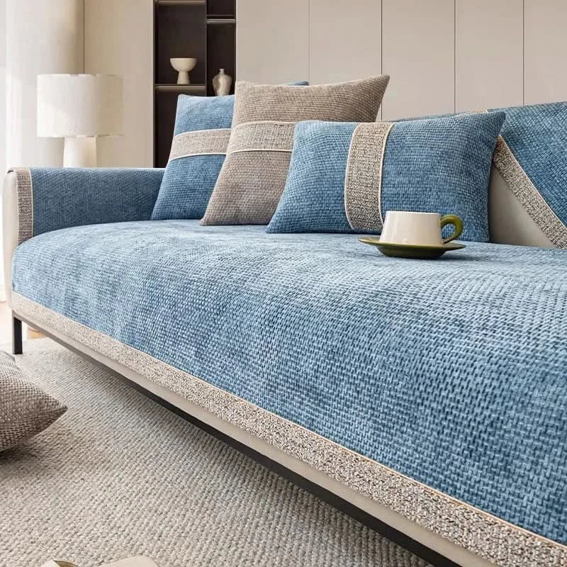 Blue sofa with patterned cushions and a cup on a saucer in a living room setting.