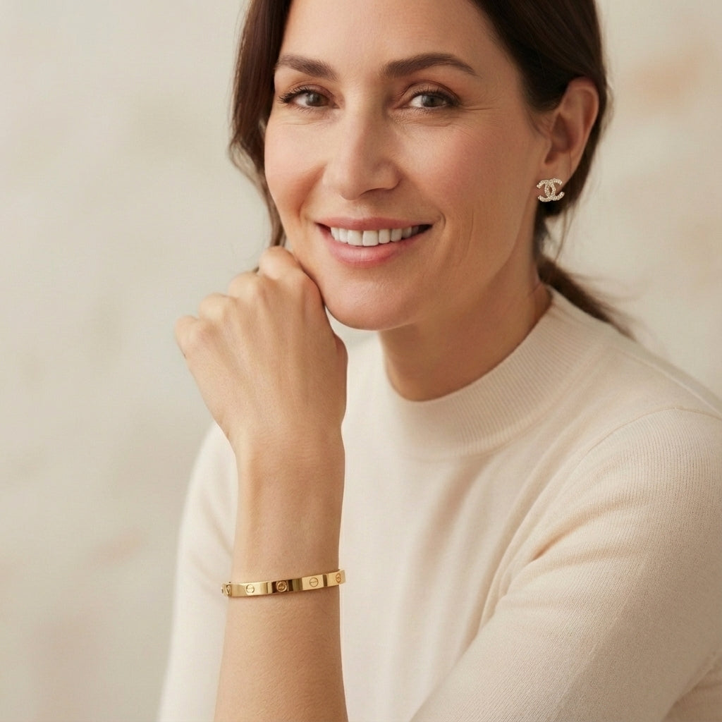Woman wearing gold jewelry against a neutral background