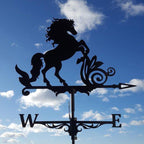 Silhouette of a rearing horse weather vane against a blue sky with clouds