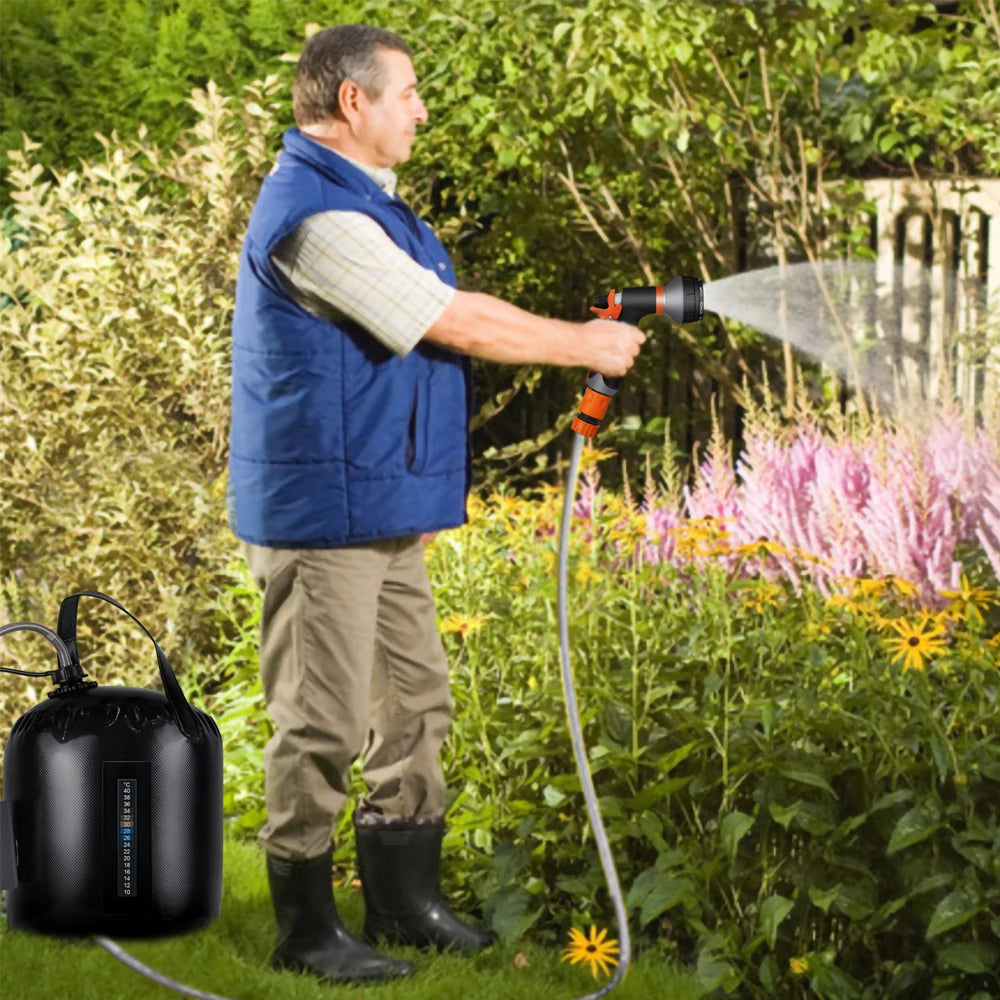 Man using a garden hose to water plants in a garden