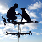 Metal weathervane of a man and dog against a blue sky with clouds