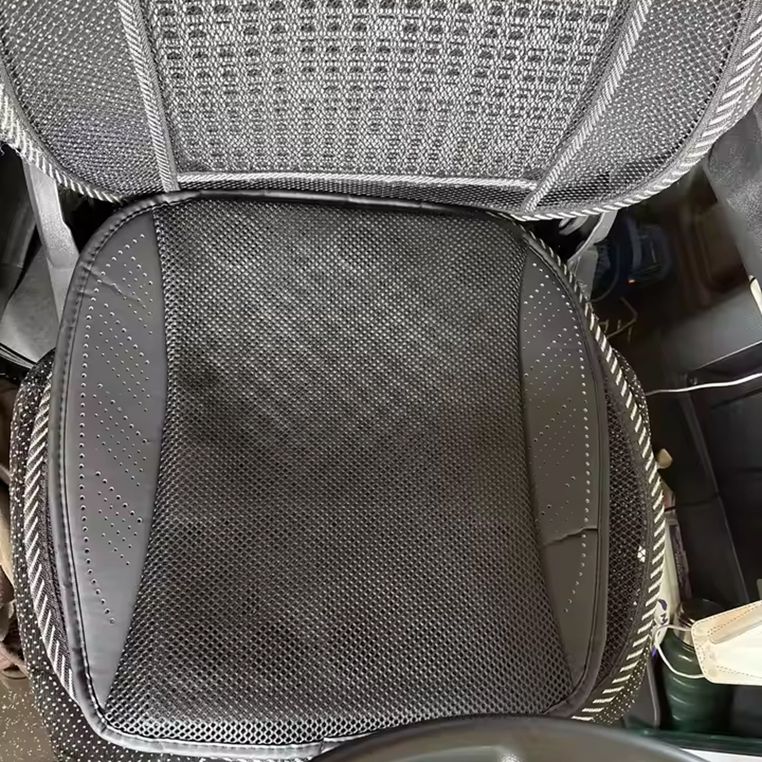 Car seat with a gray textured cover and visible wear.